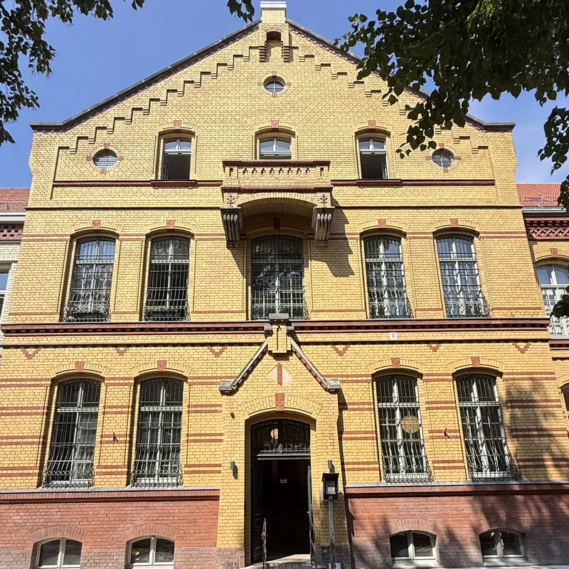 Der denkmalgeschützte Altbau von 1893, Giebel und Eingangsportal von vorn